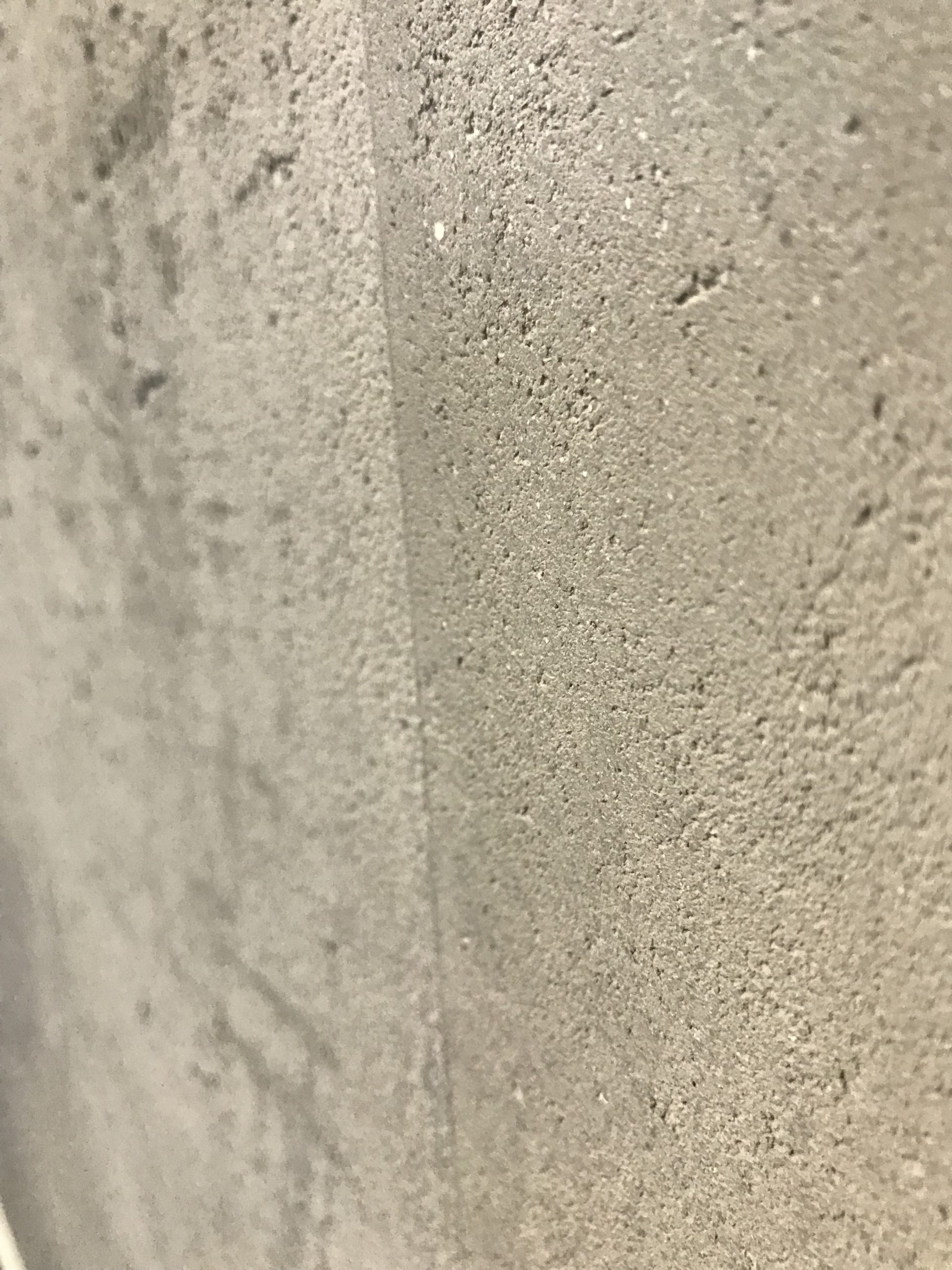 Italienischer Kalkputz mit offenporiger Steinoptik an einer Wandfläche im Raum Berlin